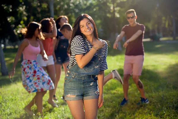 Liburan musim panas dan konsep remaja Gadis muda keluar dengan teman-teman di luar. Potret seorang gadis muda dan teman-temannya di latar belakang . — Stok Foto