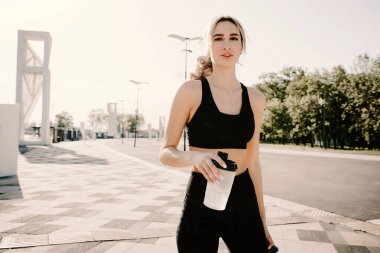 Genç atletik kız koşucu ara verip kameraya bakıyor..