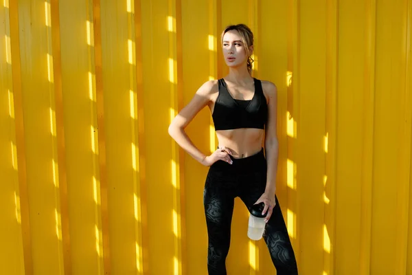 Mladá Atraktivní Sportovní Dívka Odpočívá Jogging Blízkosti Žluté Městské Zdi — Stock fotografie