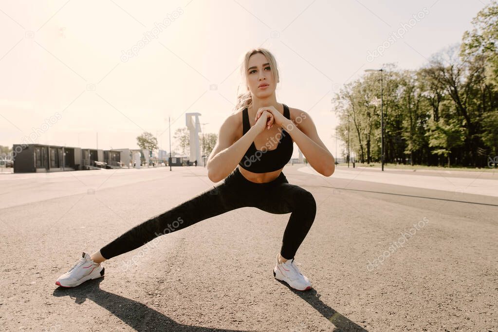 young athletic girl runner doing stretching before jogging.