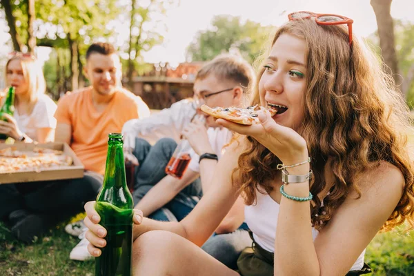Νεαρό Κορίτσι Τρώει Πίτσα Και Πίνει Μπύρα Μαζί Τους Φίλους — Φωτογραφία Αρχείου