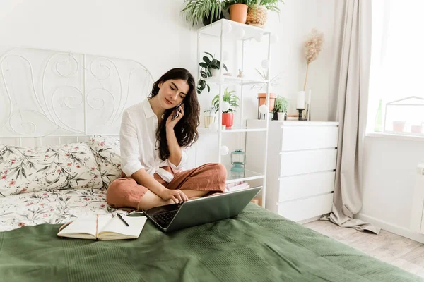 Kvinna Som Sitter Sängen Och Pratar Telefon Och Arbetar Med — Stockfoto