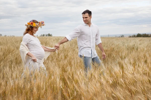 Outdoor portrait of young pregnant couple in field — Stock Photo, Image