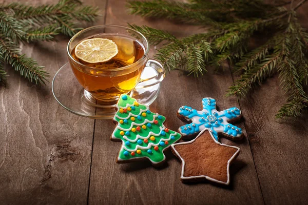 Fincan çay ve bir ahşap masa üzerinde Noel kek