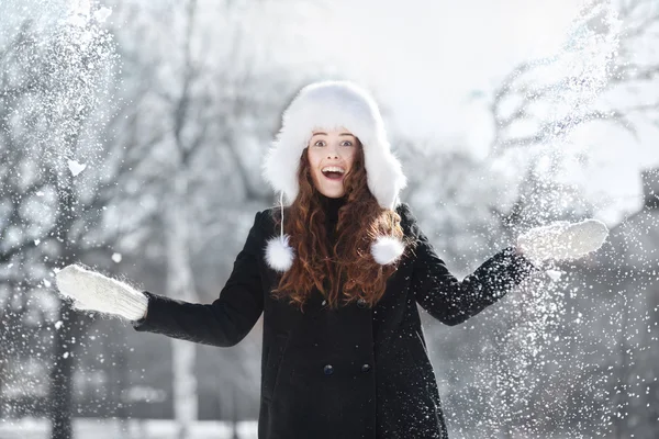 女の子は公園で雪と遊ぶ — ストック写真