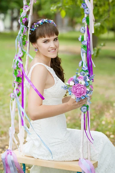 La belle mariée sur une balançoire sous un arbre — Photo