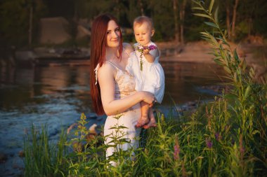 mutlu anne ve kızı günbatımında eğleniyor