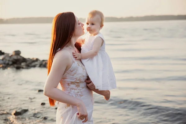 Lycklig mor och dotter ha roligt på sunset beach — Stockfoto