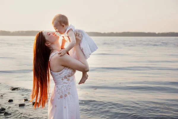 Lycklig mor och dotter ha roligt på sunset beach — Stockfoto