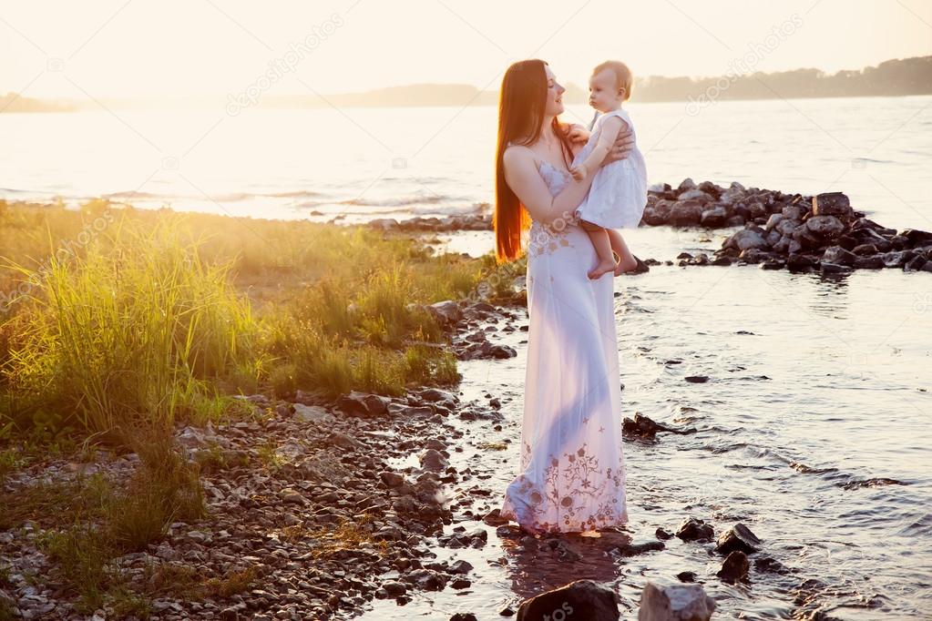 happy mother and daughter having fun at sunset