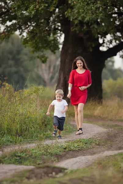 Mor och son gå av vägen i landsbygden — Stockfoto