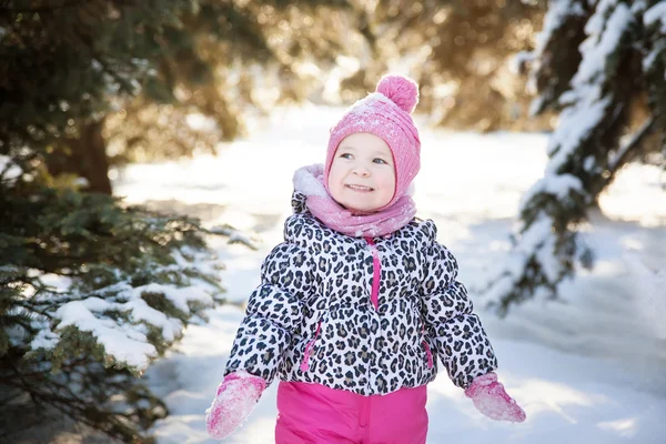 Porträtt av en liten flicka i en snöig skog — Stockfoto