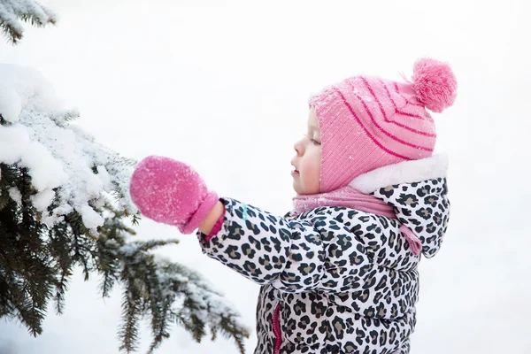 Porträtt av en liten flicka i en snöig skog — Stockfoto