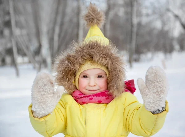 Menina engraçada em roupas de inverno em uma floresta nevada — Fotografia de Stock