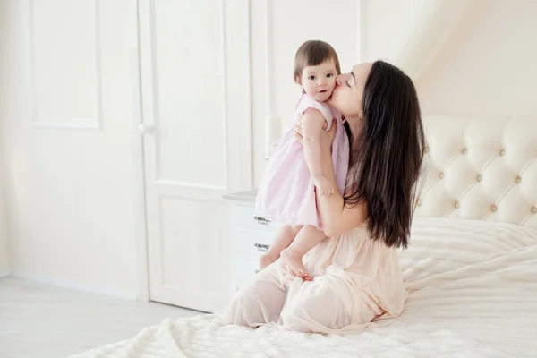 Young mother with little daughter in the bedroom — Stock Photo, Image