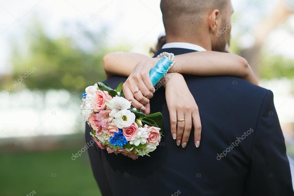 Bright colorful wedding bouquet in hands of the bride