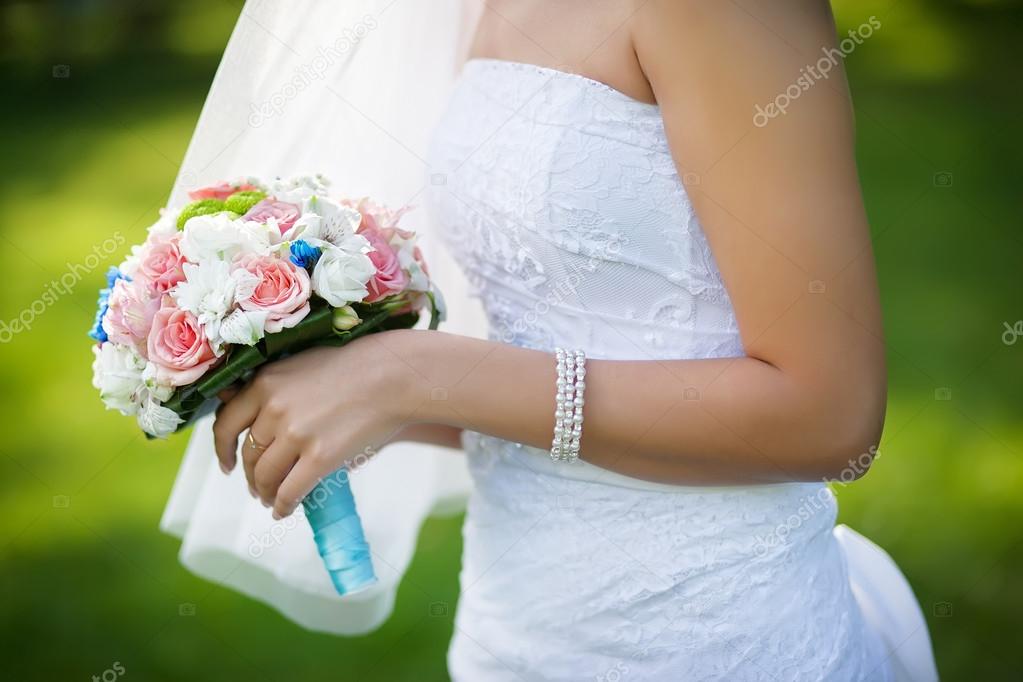 Bright colorful wedding bouquet in hands of the bride