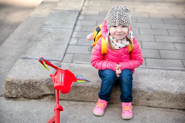 Portrét roztomilé batole dívka v růžové sako s skútr — Stock fotografie