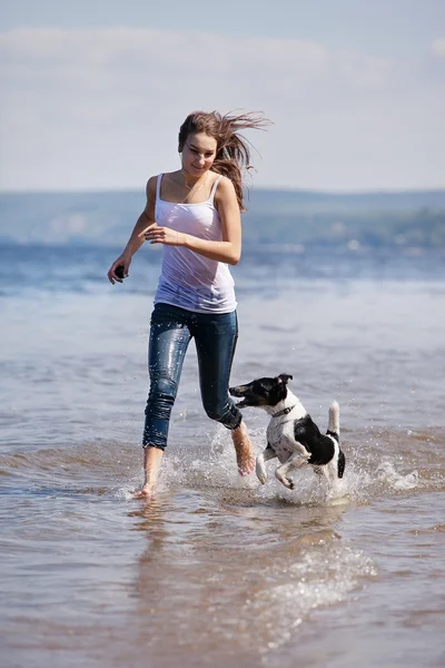 少女と犬、ビーチを走る — ストック写真