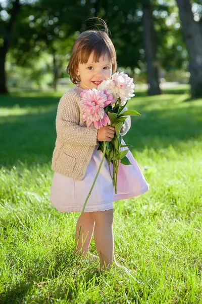 Doce menina criança com flores cacho em mãos — Fotografia de Stock