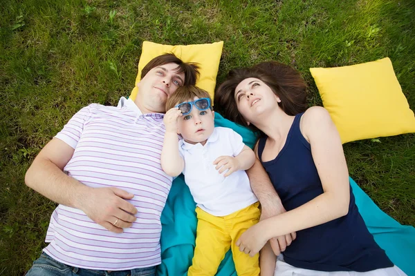 Familia feliz en una manta en el jardín , — Foto de Stock