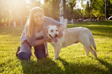 Beautiful woman playing with her dog Labrador retriever