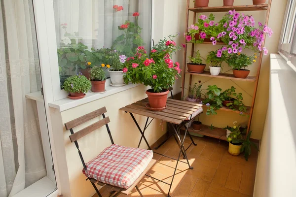 Küçük masa, sandalye ve çiçekler güzel balkon. — Stok fotoğraf