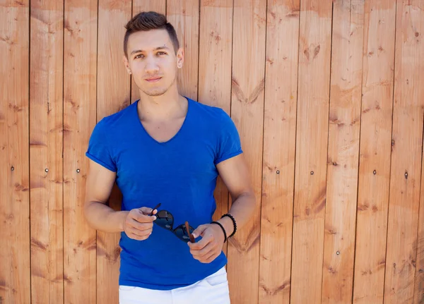 Joven guapo en la pared de madera —  Fotos de Stock