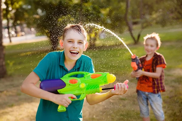 Meninos se divertindo brincando com armas de água — Fotografia de Stock