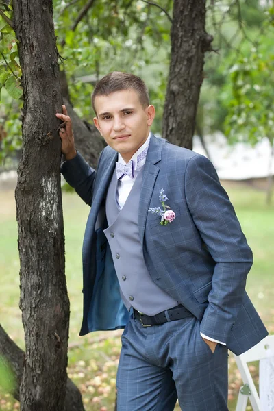 Novio en el traje de novia gris en el jardín — Foto de Stock