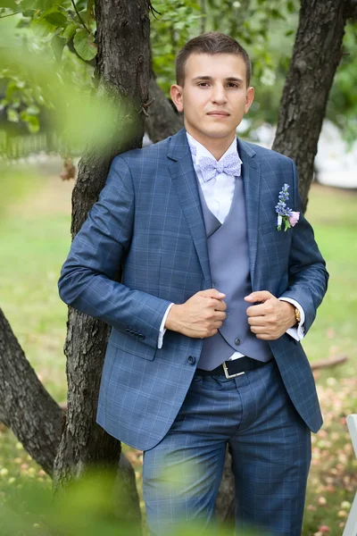 Novio en el traje de novia gris en el jardín —  Fotos de Stock