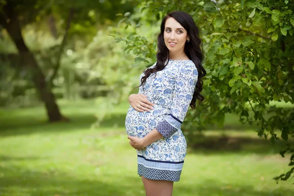 Mooie zwangere vrouw in een park — Stockfoto