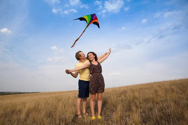 Glückliches junges Paar verliebt in Drachenfliegen auf dem Lande — Stockfoto