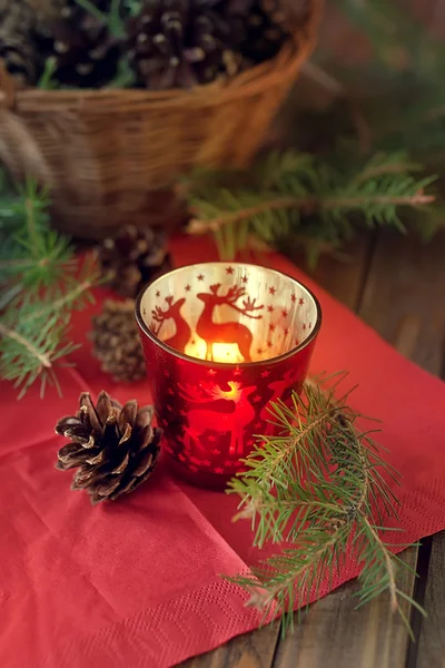 Basket with pine cones and a candle on a wooden table — Stock Photo, Image