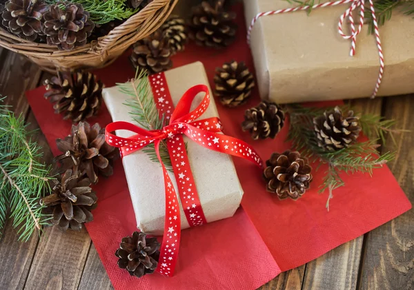 Різдвяні подарунки і шишки і на дерев'яному столі — стокове фото