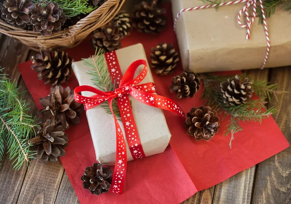 Presentes de Natal e cones e em uma mesa de madeira — Fotografia de Stock