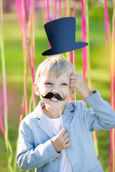 Маленький мальчик в смешных бумажных усах и шляпе — стоковое фото