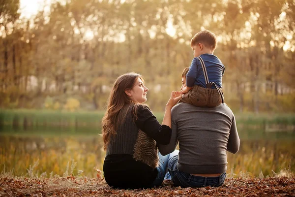 Familia en bosque de otoño, vista desde atrás — Foto de Stock