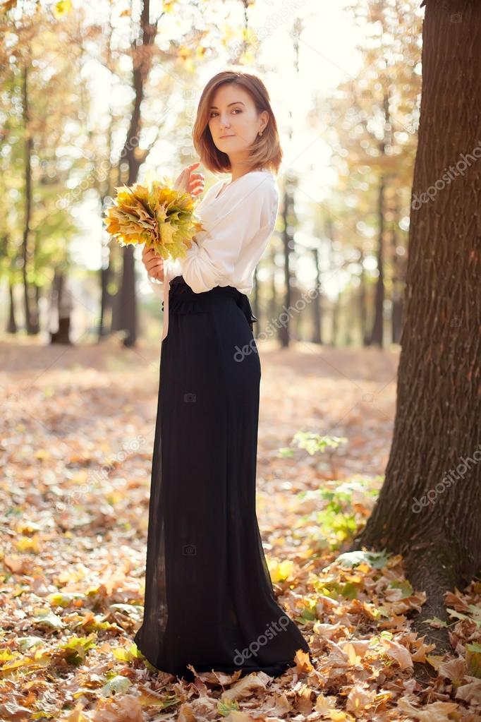 portrait of elegant slim young girl in autumn park