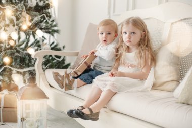 Sevimli küçük kız ve erkek kardeşim yakınındaki bir Noel ağacı