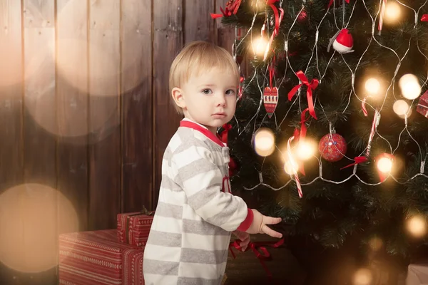 Menino de pijama na árvore de Natal — Fotografia de Stock