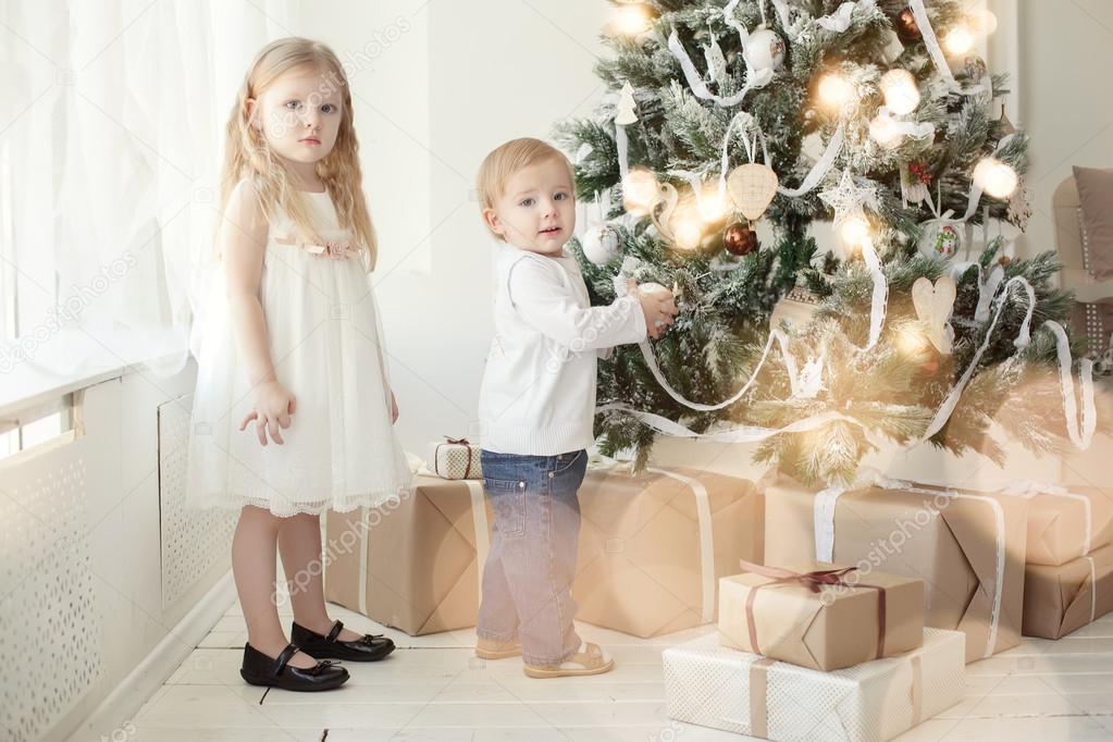Cute little  brother and sister near a Christmas tree