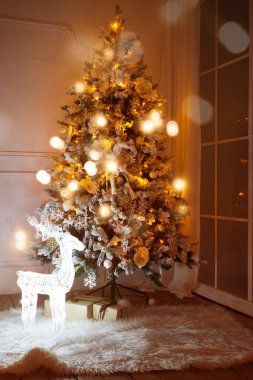 Işıklı Noel ağacı ile altında oturma odasında sunar.