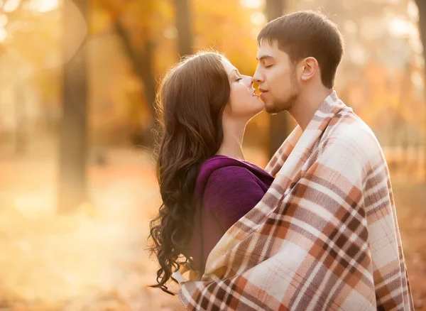 Verliefde paar verpakt in een deken in de herfst bos — Stockfoto