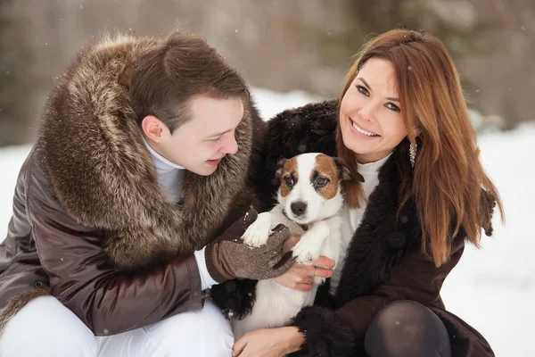 Happy couple and their dog Jack Russell Terrier at the winter park — Stock Photo, Image