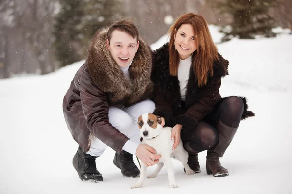 Casal feliz e seu cão Jack Russell Terrier no parque de inverno — Fotografia de Stock