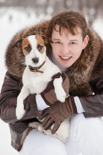 Молодой красавец с симпатичной собакой - Джек Рассел Терьер, зимний сезон . — стоковое фото