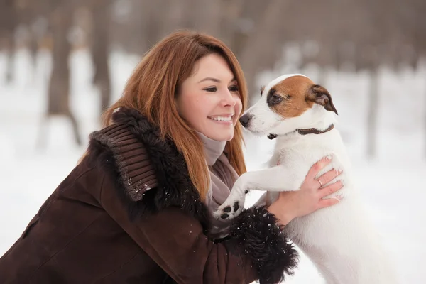Jonge roodharige vrouw buitenshuis met schattige hond - Jack Russell Terrier, winterseizoen. — Stockfoto
