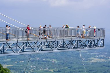 SANA, HAINAN, ÇİN - 11 Ekim: Turistler 11 Ekim 2019 'da Sanya, Hainan, Çin' de Yanoda Yağmur Ormanı Kültür Turizm Bölgesi 'nde cam köprüde fotoğraf çektiler
