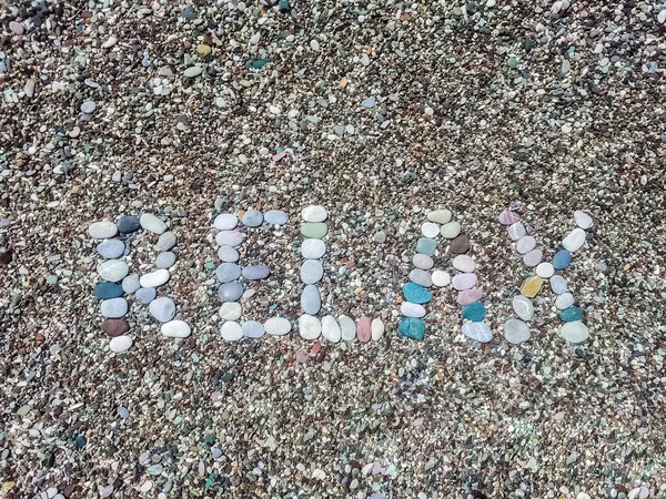 Relax word from stones on pebble beach — Stock Photo, Image